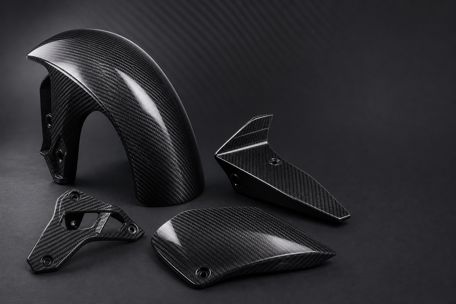 Gloss twill carbon fiber motorcycle components on a graphite studio background